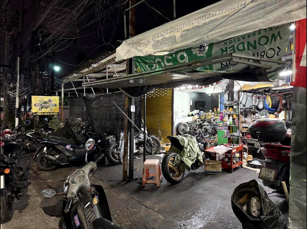 Boy Motorbike workshop street view at night with bikes parked outside